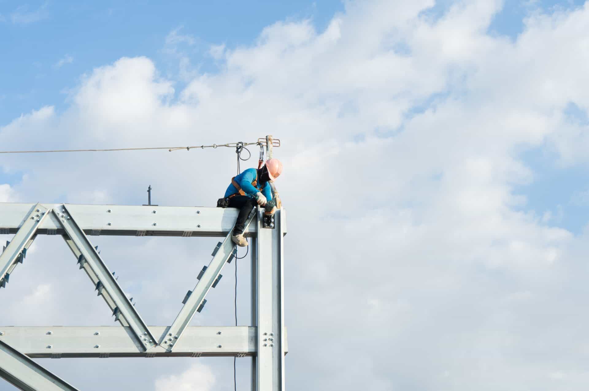 A construction worker in high-visibility gear navigating a timber roof frame, highlighting safety compliance and working at heights certification for residential building sites.