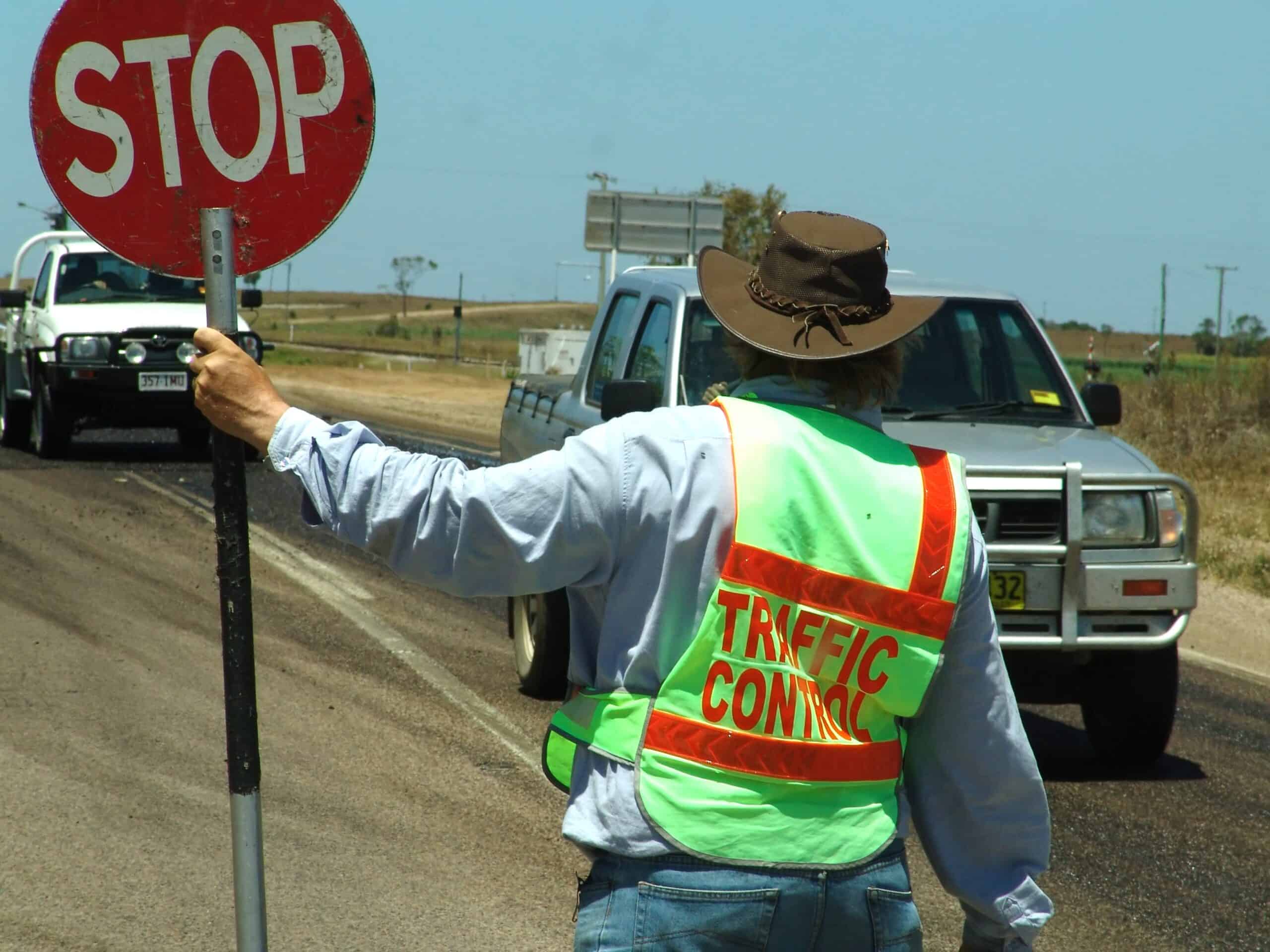 Link Resources traffic control course traffic controller stopping vehicles with stop sign on rural road