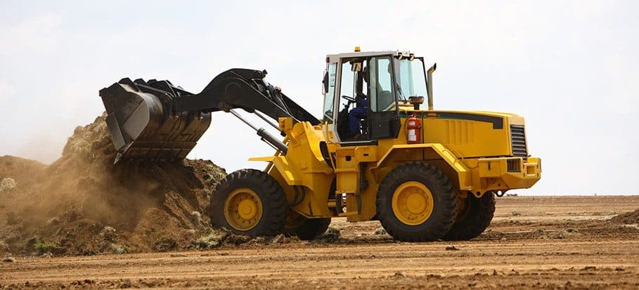 Front End Loader Training student operating a wheeled loader at a Link Resources civil construction facility.