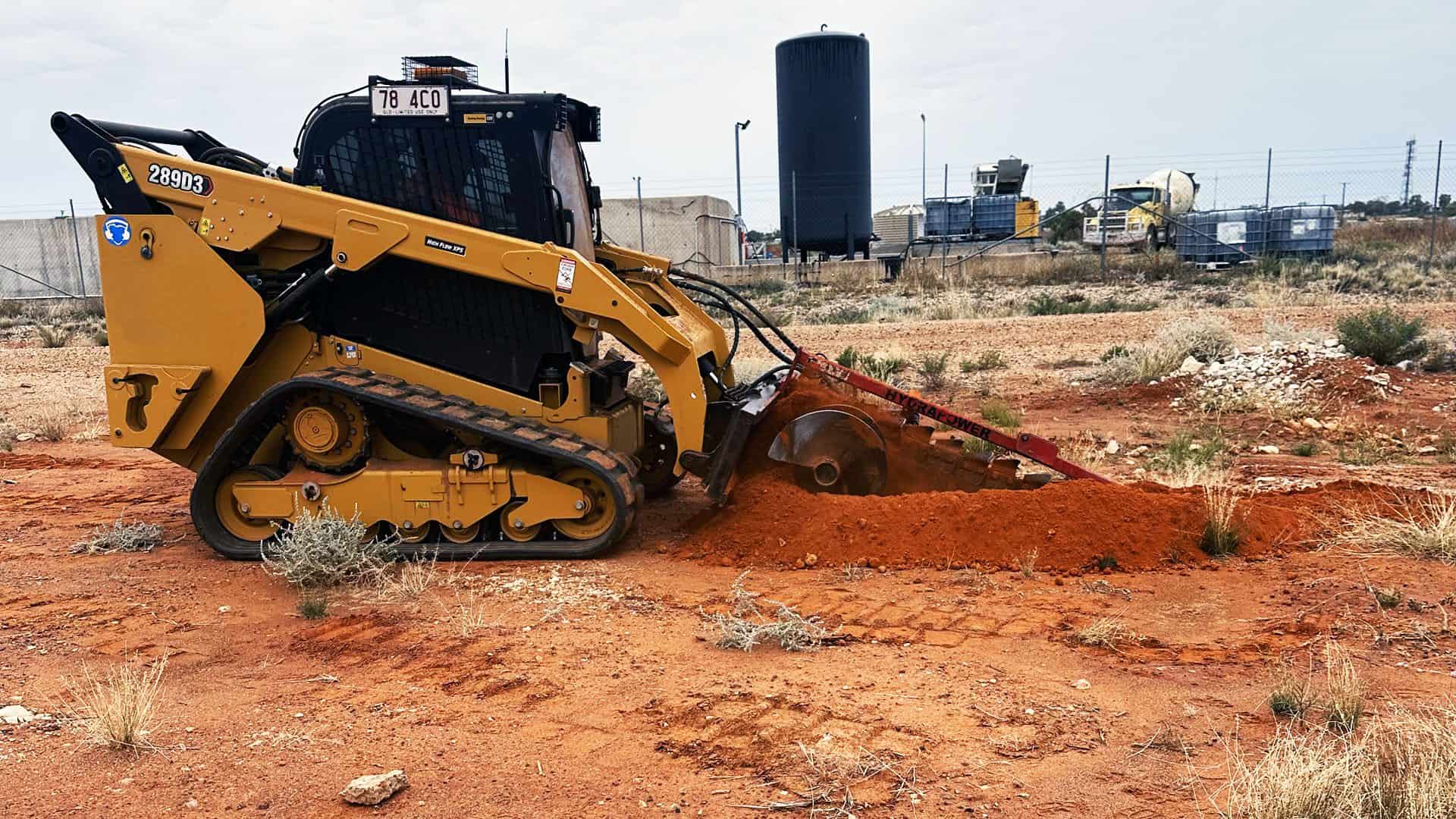 Link Resources skid steer training machine operating on a construction site moving red soil