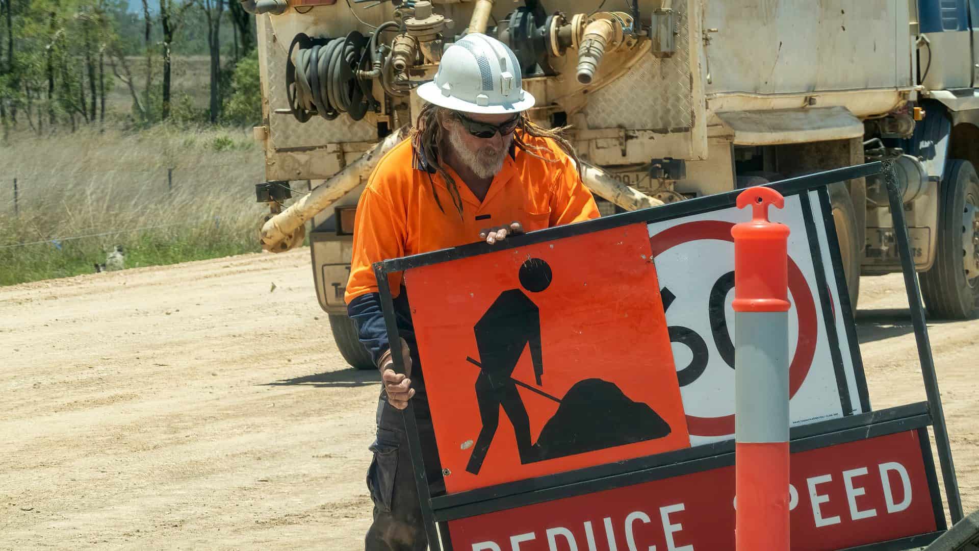 Link Resources traffic management worker placing roadwork sign on construction site